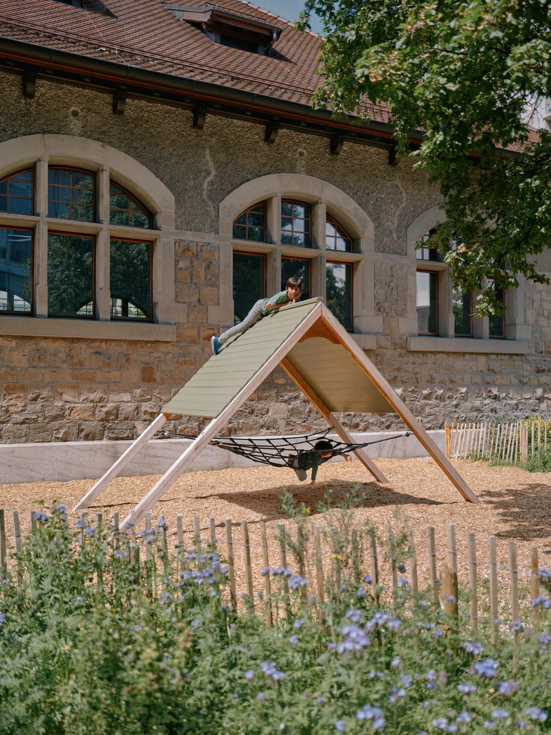 Structure de jeux en bois et plantes fleuries — préau du Collège de la Veveyse photo ©Nicolas Delaroche | Forster Paysages